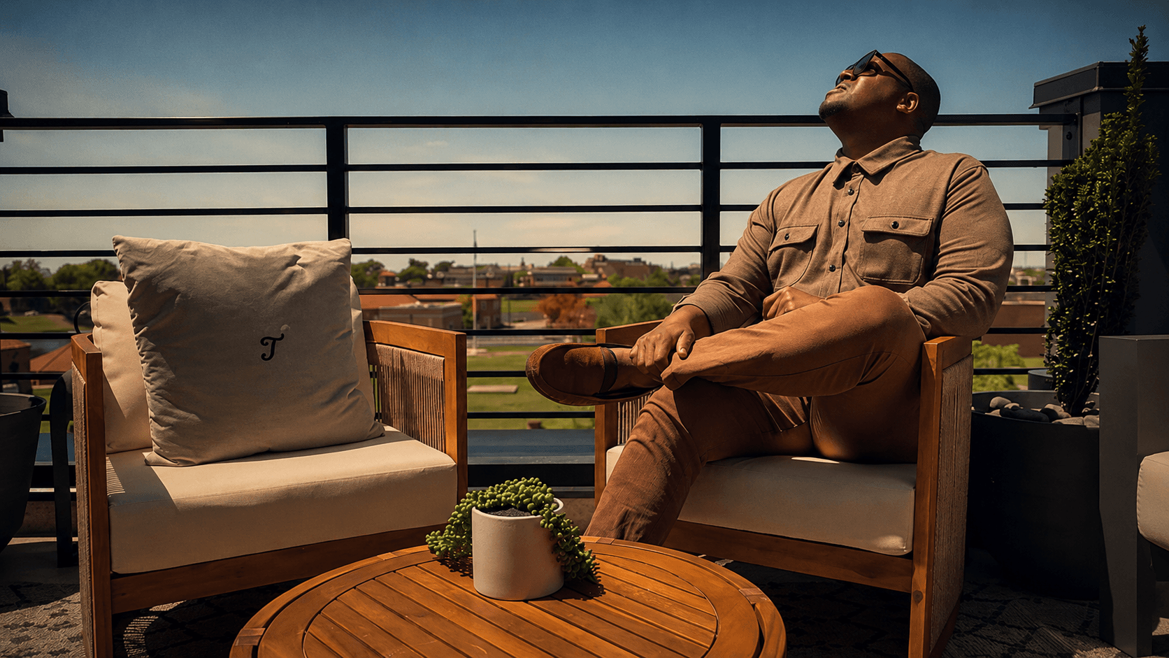 Shannon Travis seated on the Pond & Perch rooftop, looking up at the open sky.